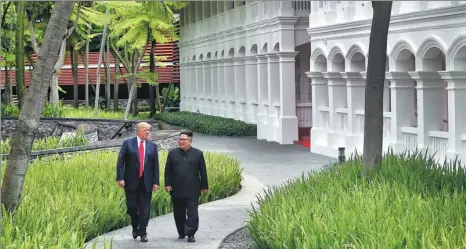  ?? KEVIN LIM / THE STRAITS TIMES ?? US President Donald Trump walks with the DPRK’s top leader Kim Jong-un at the Capella hotel on Sentosa island in Singapore on Tuesday.