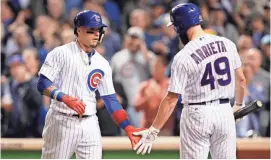  ?? JIM YOUNG/USA TODAY SPORTS ?? Cubs second baseman Javier Baez celebrates with Jake Arrieta (49) after hitting a solo home run Wednesday night. The Cubs forced a Game 5 with the win.