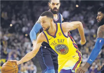  ?? Paul Kuroda / Special to The Chronicle ?? Stephen Curry of the Warriors splits the defense of Oklahoma City Thunder center Steven Adams (left) and forward Paul George during Golden State’s 112-80 victory.