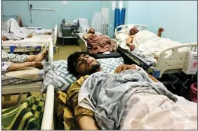  ?? (AP/Mohammad Asif Khan) ?? Wounded Afghans lie on beds at a hospital after explosions outside the airport in Kabul.