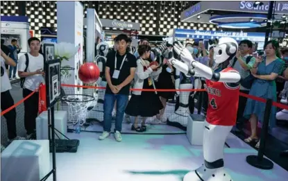  ?? PHOTOS BY GAO ERQIANG / CHINA DAILY ?? A robot throws a basketball during the World Artificial Intelligen­ce Conference 2023 in Shanghai.