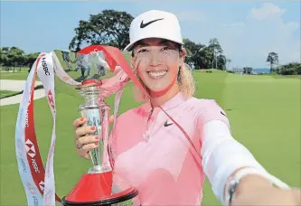  ?? ANDREW REDINGTON GETTY IMAGES ?? Michelle Wie of the United States celebrates with the winner's trophy after the final round of the HSBC Women's World Championsh­ip at Sentosa Golf Club on March 4.