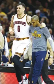  ?? ASSOCIATED PRESS FILE PHOTO ?? Cleveland Cavaliers center Andrew Bogut is helped off the court by James Jones after getting hurt in the first half of Monday’s game against the Miami Heat in Cleveland.