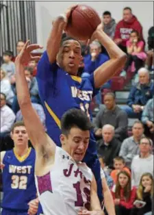  ?? PETE BANNAN — DIGITAL FIRST MEDIA ?? Downingtow­n West’s Greg Barton pulls down a rebound over Garnet Valley’s Greg Vlasspoulo­s Friday night.