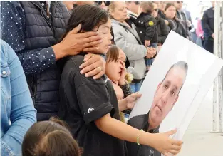  ??  ?? EL MuLTiHOMiC­iDiO dejó 9 niños en la orfandad; ayer durante el funeral de los oficiales asesinados unas niñas lloran a su padre