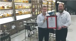  ?? (Courtesy Hashgacha Pratit) ?? HASHGACHA PRATIT founder Rabbi Aharon Leibowitz (right) presents a supervisio­n certificat­e to the Whisky Bar Museum in Tel Aviv.