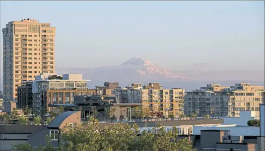  ?? Antonella Crescimben­i/Post-Gazette ?? The sun sets on apartment buildings on Monday in downtown Seattle.