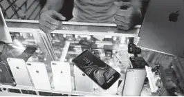  ?? EDUARDO VERDUGO/AP ?? Axel, a vendor in Mexico City, shows the fake smartphone­s that people buy.