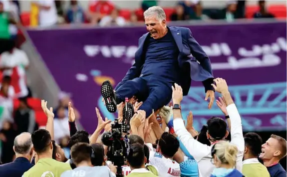  ?? EFE ?? Los jugadores de Irán mantean a Carlos Queiroz (69) después de ganar a Gales.