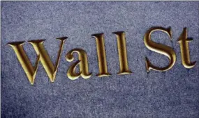  ?? MARK LENNIHAN — THE ASSOCIATED PRESS FILE ?? A sign for Wall Street is carved into the side of a building in New York.