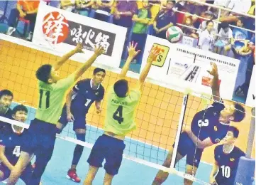  ??  ?? A Sarawak player going for a spike as Penang players attempt to block. Penang won the group match 3-2. — Photo by Othman Ishak