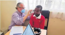  ?? ?? Newly qualified Audiologis­t Sean carrying out a hearing test on a Kenyan child