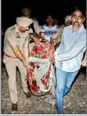  ?? PTI ?? Police and volunteers carry a victim from the site of a train accident at Joda Phatak in Amritsar