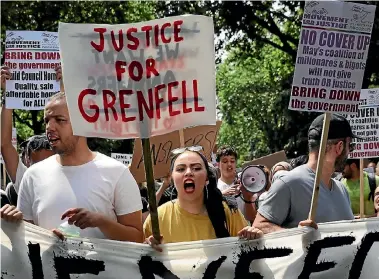  ?? PHOTO: GETTY IMAGES ?? Protesters hold signs calling for justice for the victims of the Grenfell disaster during a ‘‘Day of Rage’’ organised by the Movement for Justice By Any Means Necessary.