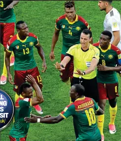  ?? AP ?? Chaos: ref Roldan is surrounded by Cameroon players