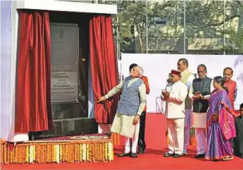  ?? PTI ?? Prime Minister Narendra Modi unveils a plaque to dedicate Dr Ambedkar Internatio­nal Centre to the nation, in New Delhi yesterday. Modi faces a key test of his popularity after a series of controvers­ial economic reforms when the state where he forged his political career goes to polls.