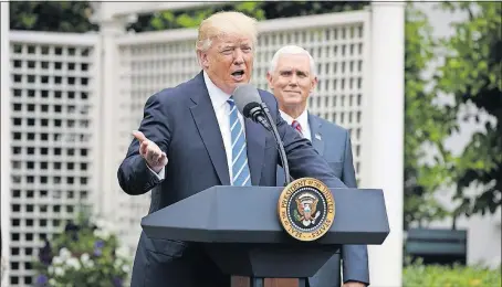  ?? [EVAN VUCCI/THE ASSOCIATED PRESS] ?? President Donald Trump, accompanie­d by Vice President Mike Pence, speaks to members of the Independen­t Community Bankers Associatio­n on Monday in the Kennedy Garden of the White House.