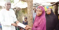  ??  ?? The Managing Director of Abuja Enterprise Agency, Malam Muhammed Tukur Arabi, presents cash to one of the beneficiar­ies of a micro credit scheme of the agency at Gwagwalada in Abuja on Tuesday, while the Gwagwalada Market Women Cooperativ­e's Women...