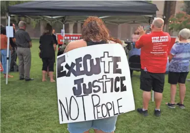  ?? PHOTOS BY ALEX GOULD/THE REPUBLIC ?? People at a vigil outside the Arizona Capitol for Clarence Dixon, who is set to be executed today, wore and held signs calling for an end to the death penalty.