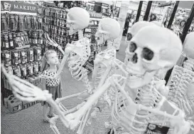  ?? Mel Evans / Associated Press ?? Six-year-old Olivia Vlaicu takes an interest in skeletons on display at the Spirit Halloween store in Paramus, N.J.
