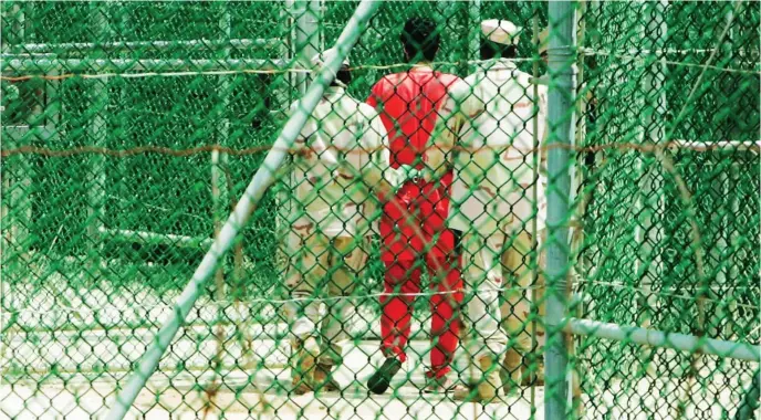  ?? ?? Militares estadounid­enses escoltan a un preso en el centro carcelario del Caribe