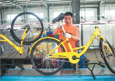  ?? WANG WEIWEI / FOR CHINA DAILY ?? A worker assembles an Ofo bike at a plant in Tianjin.