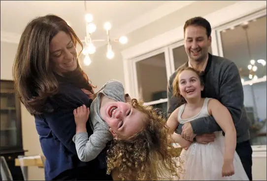  ?? Chicago Tribune/TNS/JIM YOUNG ?? Lindsay Pinchuk and her husband, Daniel, play with their daughters Lila, 3, and Jordyn, 6, at their home in Northbrook, Ill.