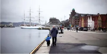  ??  ?? File photo on March 20, 2012 shows a man walking with a child near the marina in downtown Bergen, southweste­rn Norway. — Reuters photo