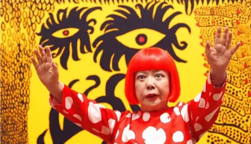  ?? ?? Japanese artist Yayoi Kusama poses for photograph­ers at the 'Earth Carrying with it a Tale of the Cosmos' at the Tate Modern in London, 2012.