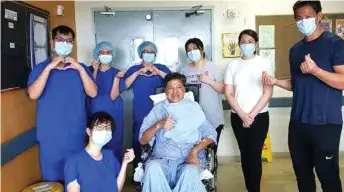  ??  ?? Wong poses with hospital staff and family members in a hospital ward.