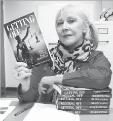  ?? NICK BRANCACCIO ?? Journalist Veronique Mandal displays her new book, Getting Off, a biography on Windsor criminal lawyer Don Tait.