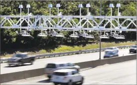  ?? Elise Amendola / Associated Press ?? Cars pass under toll sensor gantries hanging over the Massachuse­tts Turnpike in Newton, Mass., in 2016.