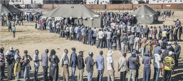  ??  ?? 0 As controvers­y mounted over delays in voting, people queue to cast their votes outside a polling station in the suburb of Mbare in Zimbabwe’s capital Harare