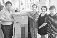  ??  ?? Anita, Chong and Teo hand over the water purifiers to headmaster Wong.