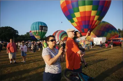  ?? PHOTO BY WILLIAM J. KEMBLE ?? Claverack residents Shanaaz and James Bell with three-year-old Sam Bell watch as hot air balloons prepare for lift off at the Dutchess County Fairground­s on Saturday morning.