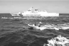  ?? AFP ?? This photo taken on Feb. 16, 2024 shows Filipino fishermen aboard their wooden boats (middle L and 2nd L) and Philippine Fisheries and Aquatic Resources personnel aboard their rigid hull inflatable boat (foreground C) sailing past a Chinese coast guard ship (top) near the China-controlled Scarboroug­h Shoal, in disputed waters of the South China Sea.