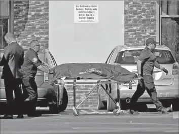  ?? Gary Coronado Los Angeles Times ?? CORONERS REMOVE a body from the Monterey Park massacre scene. L.A. County supervisor­s on Tuesday passed about half a dozen measures, including one on safe storage of guns, aimed at curbing fatal shootings.