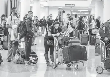  ?? — Gambar AFP ?? SESAK: Para pelancong menunggu giliran di ruang pemeriksaa­n di Lapangan Terbang Los Angeles, California kelmarin.