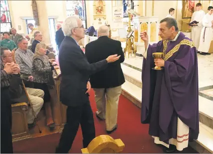  ?? Brian A. Pounds / Hearst Connecticu­t Media ?? Bishop Frank Caggiano gives communion during a Mass of Hope, Healing, and Reconcilia­tion for victims of clerical sexual abuse at St. Joseph Church in Danbury on Sunday.