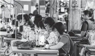  ??  ?? Employees at the C.C. Filson Co. manufactur­ing facility work at their sewing machines in Seattle. America has outperform­ed other advanced economies and ranks among the world’s most competitiv­e countries.