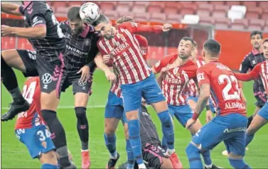  ??  ?? La zaga del Sporting despeja el balón ante el cabezazo de Aitor Sanz, jugador del Tenerife.