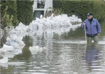  ?? PIERRE OBENDRAUF ?? André Roussin checks on the water level around his brother’s home on St-Jean-Baptiste St. in Oka on May 9. Even on an island like Montreal, experts say much can be done to minimize flood risks.