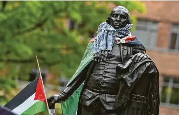 ?? Foto: Celal Gunes, Anadolu/afp ?? Eine Statue von George Washington ist mit einer palästinen­sischen Flagge versehen. Studenten der George-Washington-Universitä­t üben Protest gegen den Krieg zwischen Israel und der Hamas.