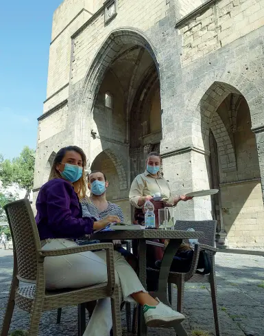  ??  ?? Alcune immagini dei tavolini e degli ombrelloni sistemati all’interno del cortile di Santa Chiara