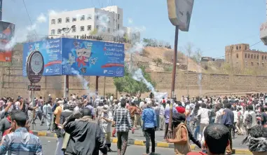  ?? BROTHER AGAINST BROTHER: Houthi fighters and pro-Houthi police troopers fire tear gas on anti-Houthi protesters in Yemen’s south-western city of Taiz yesterday.
PICTURE: REUTERS ??