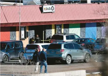  ?? JASON CONNOLLY/GETTY-AFP ?? Law enforcemen­t officers walk through the parking lot of Club Q, an LGBTQ nightclub, in Colorado Springs, Colorado, on Sunday. At least five people were killed and 25 wounded in a mass shooting at the club, police said.