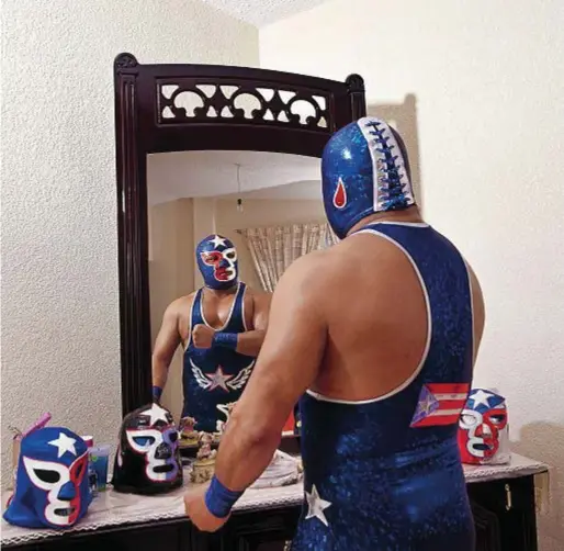  ??  ?? Un lottatore e le sue maschere. Per circa 40 anni, la fotografa ha documentat­o la vita privata degli atleti.