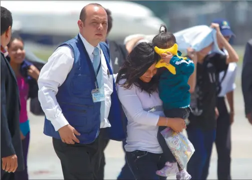  ?? MOISES CASTILLO / ASSOCIATED PRESS ?? A mother and daughter, who were deported from the United States, are escorted by an immigratio­n agent upon their arrival to La Aurora Internatio­nal Airport in Guatemala City on Friday. They were among a group of children accompanie­d by their parents...