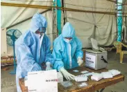  ?? Sam Panthaky / AFP / Getty Images ?? Medical workers prepare coronaviru­s testing materials at a site near Ahmedabad, India.