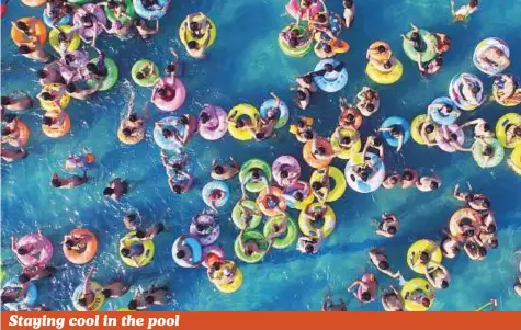  ?? AFP ?? People cool off in a swimming pool in Yangzhou, Jiangsu province, yesterday. The current heatwave is forecast to continue and hit more of the country, with people being warned to protect themselves from the sun.